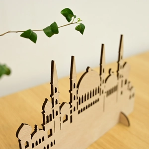 Detail of laser-cut wooden Islamic architectural skyline decor on a minimalist desk