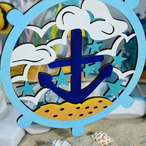 Detailed close-up of nautical wooden anchor and helm ornament on real beach sand with shells