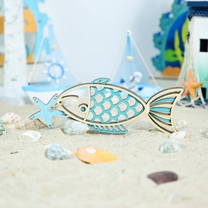 Close-up of wooden fish hanging ornament with laser-cut scales and a blue starfish detail