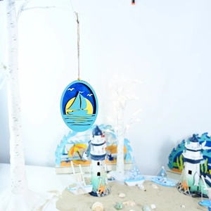 Detail of wooden ocean sailboat wall hanging with layered laser-cut design and jute rope