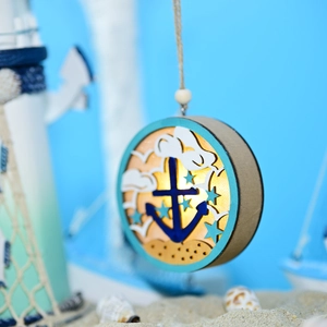 Macro detail of nautical wooden LED ornament with anchor design and ocean-themed background