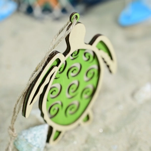 Detail view of a laser-cut wooden sea turtle wall hanging with green shell and jute rope