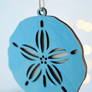 Detail of blue wooden nautical ornament with laser-cut star pattern and natural jute rope
