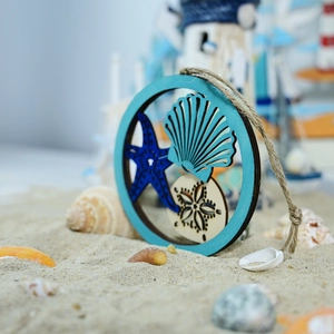 Detail of wooden ocean wall decor featuring starfish and shells on a sandy beach background