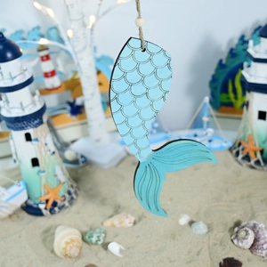 Detail of blue wooden mermaid tail hanging ornament with nautical textures and rustic rope
