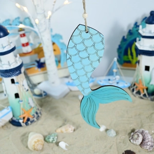Detail of wooden mermaid tail pendant with blue scales for coastal home wall decoration