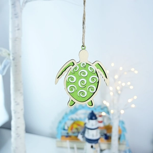Detail view of the wooden sea turtle ornament with white swirl patterns on green wood