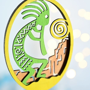 Detail of wooden Kokopelli ornament featuring laser-cut patterns and tribal motifs