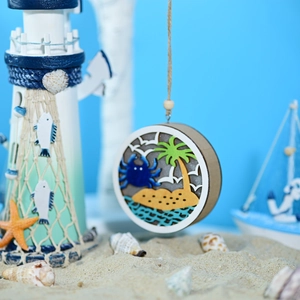 Detail view of tiered wooden ocean ornament with blue crab and island silhouettes