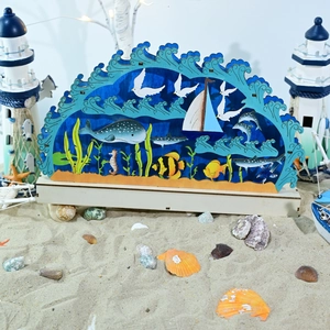 Dettaglio scultura 3D in legno scena marina con balena e delfini su base in legno naturale