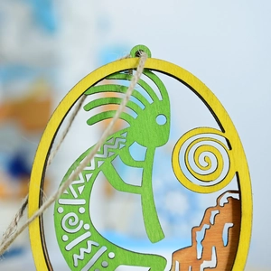Detail of laser-cut wooden Kokopelli wall hanging with green deity and mountain base
