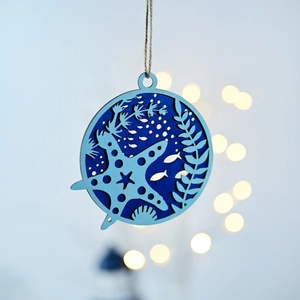 Close-up of circular ocean theme wooden ornament with starfish and fish cutout details