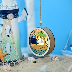 Detail of wooden ocean ball LED light with multi-layer carved crab and palm tree scene