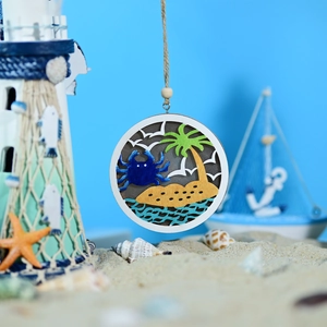 Detail of wooden LED ocean ball light with layered crab and palm tree carvings