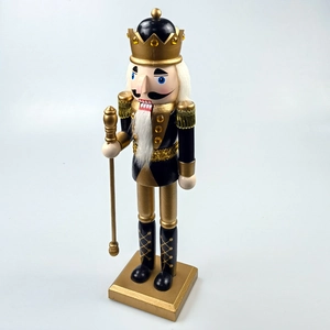Detail of a black and gold wooden nutcracker soldier with crown and golden scepter