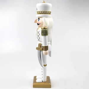 Detail of white and gold wooden nutcracker soldier with intricate crown and saber