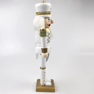 Detail of white and gold nutcracker soldier featuring fiber hair and rhinestone buttons