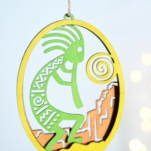 Detail of multi-layered laser cut wood Kokopelli wall art with nautical hemp rope hanging