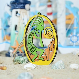 Detail of wooden Kokopelli pendant with nautic decor elements on a beach background
