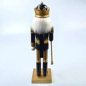 Detail of black and gold nutcracker king with white plush beard and golden scepter