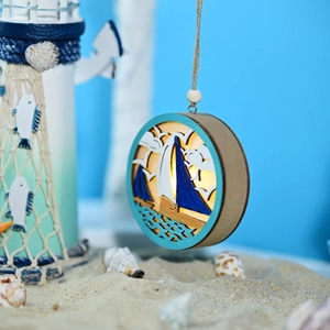 Detail of wooden LED ocean ball lamp with multi-layer laser cut sailboat and warm lighting