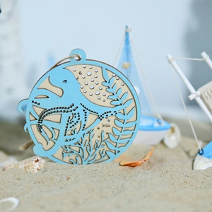 Close-up of a blue carved wooden octopus ornament with nautical accents on sand