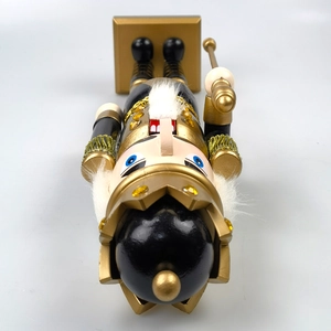 Top-down view of black and gold nutcracker figurine with crown and royal scepter