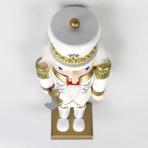 Close-up of a 30cm white and gold Christmas nutcracker soldier with a silver saber