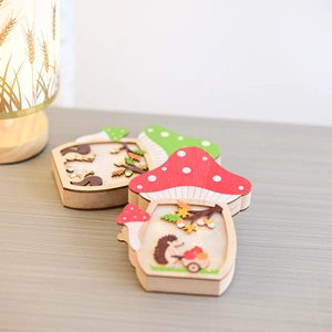 Detailed view of wooden mushroom ornaments featuring hand-painted forest animal scenes
