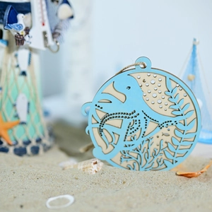 Detail of laser-cut octopus wooden wall hanging with jute rope in a beach setting