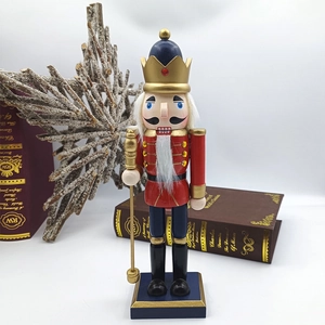 Detail of red nutcracker soldier with gold crown and scepter on vintage bookshelf