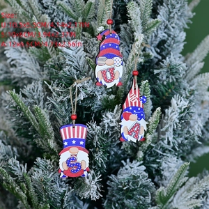 Three USA patriotic gnome wooden ornaments hanging on snow-covered pine branches