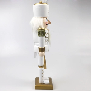 Side view of white and gold nutcracker soldier with tassels and rhinestone details