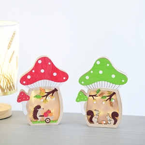 Detail of wooden mushroom lights with LED warm glow and cute forest animal carvings