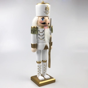 Detail of white and gold nutcracker soldier with intricate golden tassels and sequins