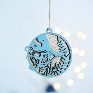 Detail of round octopus nautical ornament with laser-cut wood patterns and natural twine