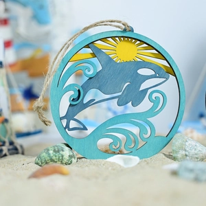 Detailed layered wood wall art showing an orca jumping from waves with sun rays