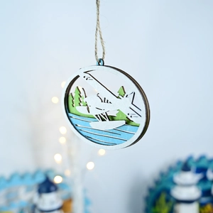 Makroaufnahme von mehrschichtigem Holzschmuck mit Wasserflugzeug und Waldmotiv