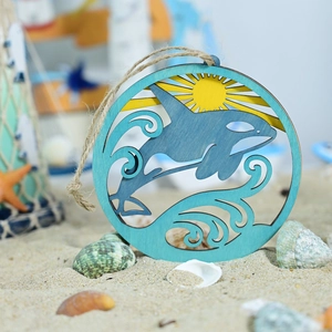 Detail of multi-layered wooden whale ornament on beach sand with nautical decorations