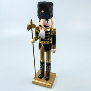 Detail of black and gold Nutcracker soldier with a golden axe and fringed epaulettes