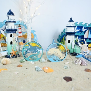 Detail of wooden ocean wall plaques with laser-cut orca and dolphin in beach setting