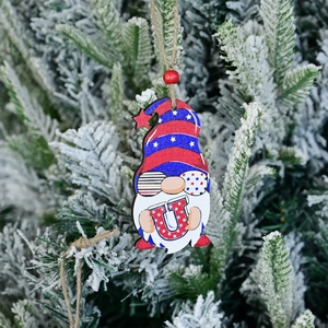 Detail of wooden gnome hanging decoration with US flag pattern on a snowy pine branch