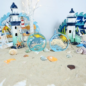 Detail of wooden ocean ornaments with whale and dolphin designs on beach sand