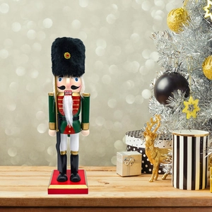 Close-up of green Nutcracker soldier on wooden desk with bokeh festive lights