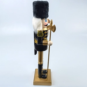 Detail of black and gold nutcracker soldier with fur hat and golden axe on base