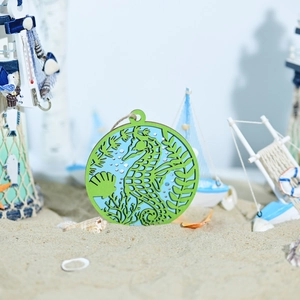 Detail of wooden sea horse wall hanging with hollow carving on sandy beach background