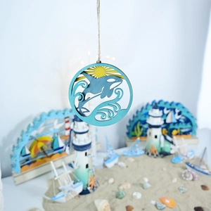 Detail of wooden ocean wall art with layers featuring a killer whale and seaside scene
