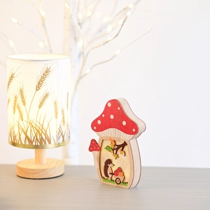Detail of wooden mushroom LED lamp with hedgehog miniature and warm harvest lights