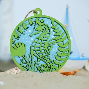 Detailed laser-cut wooden round ornament with a teal seahorse and jute rope hanger