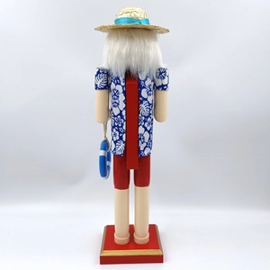 Detail view of tropical wooden nutcracker featuring Hawaiian shirt and straw hat design